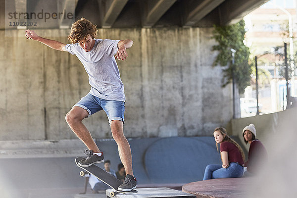 Teenager-Junge beim Skateboard-Stunt im Skatepark