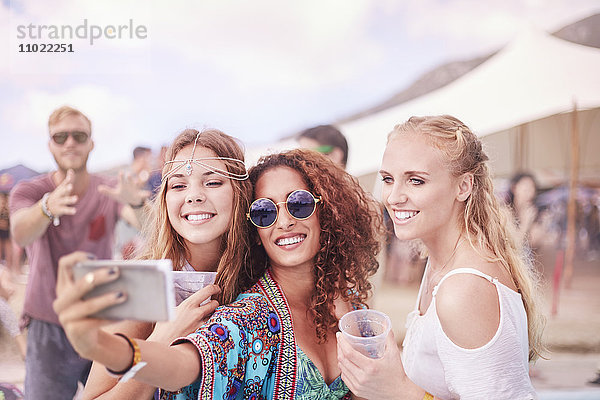Junge Frauen posieren für Selfie beim Musikfestival