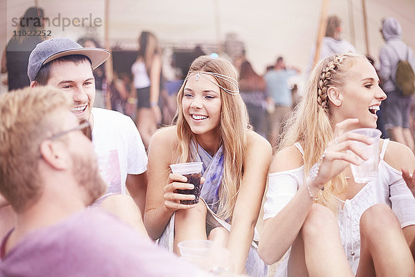 Junge Freunde beim Trinken auf dem Musikfestival