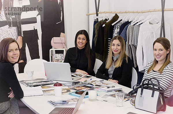 Porträt lächelnd Mode Einkäufer Sitzung in chaotisch Büro