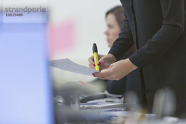 Geschäftsfrau hebt Papierkram im Büro hervor