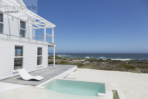 Strandhaus mit Pool und Terrasse mit Blick auf den Ozean bei strahlend blauem Himmel