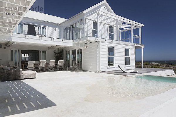 Weißes Strandhaus mit sonnigem Schwimmbad