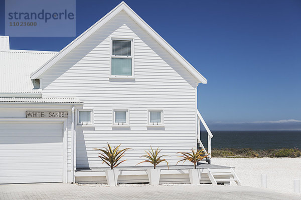 Weißes Strandhaus mit sonnigem Meerblick