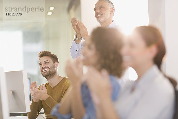 Geschäftsleute  die im Büro klatschen