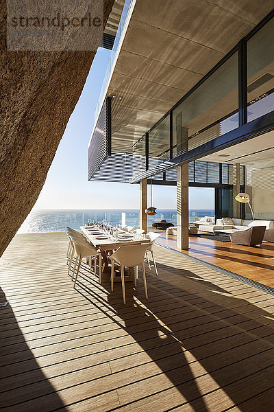 Moderner Luxus-Esstisch auf sonniger Terrasse mit Meerblick
