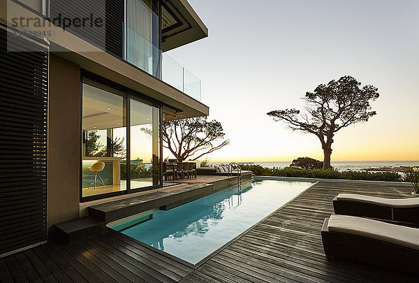 Modernes Luxushaus mit Terrasse und Swimmingpool mit Blick auf den Sonnenuntergang