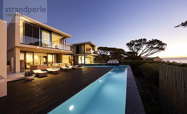 Modernes Luxushaus mit Terrasse und Swimmingpool bei Sonnenuntergang