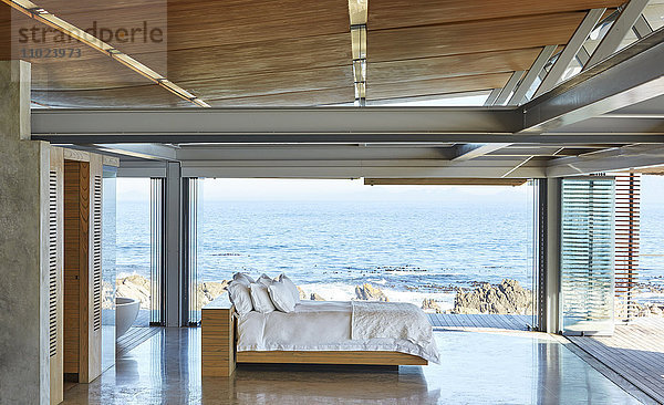 Modernes  luxuriöses Bett mit Zugang zur Terrasse und sonnigem Meerblick