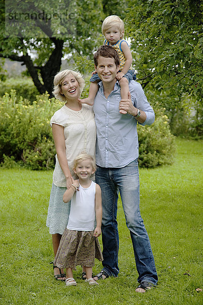 Porträt von Eltern mit zwei Kindern im Garten