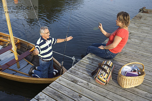 Eine Frau fotografiert einen Mann in einem Boot.
