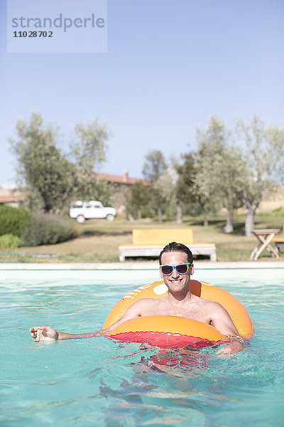 Mittlerer erwachsener Mann entspannt sich im Schwimmbad
