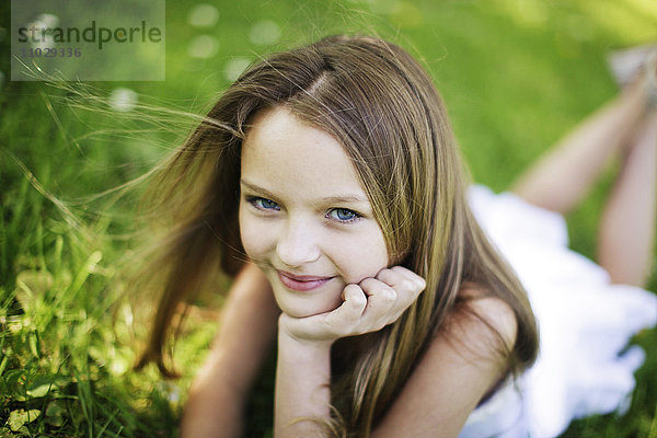 Mädchen auf Rasen liegend  lächelnd  Nahaufnahme