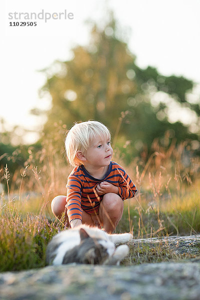 Junge mit Katze im Gras