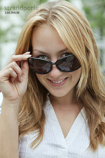 Porträt einer lächelnden Frau mit Sonnenbrille