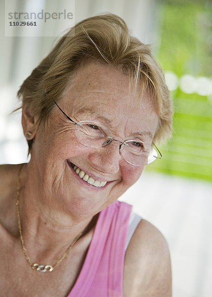 Porträt einer lächelnden älteren Frau mit Brille