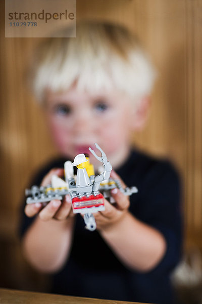 Junge spielt Lego-Raumschiff