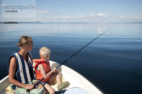 Mutter mit Sohn beim Angeln auf einem Boot