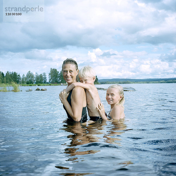 Mutter mit Kindern beim Schwimmen im See