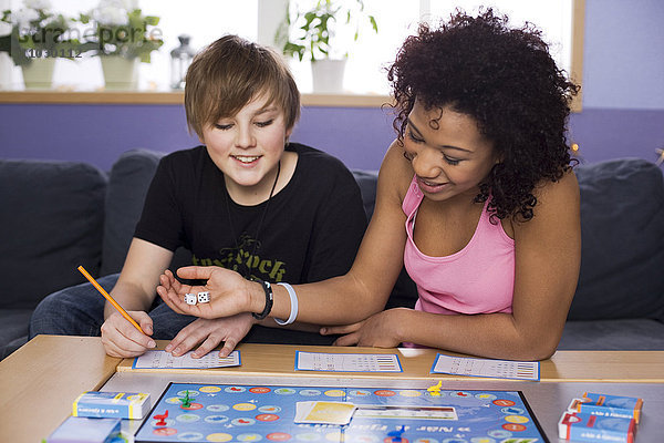 Teenager-Mädchen und Junge spielen Freizeitspiel