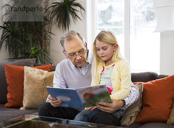 Großvater liest einem Mädchen vor