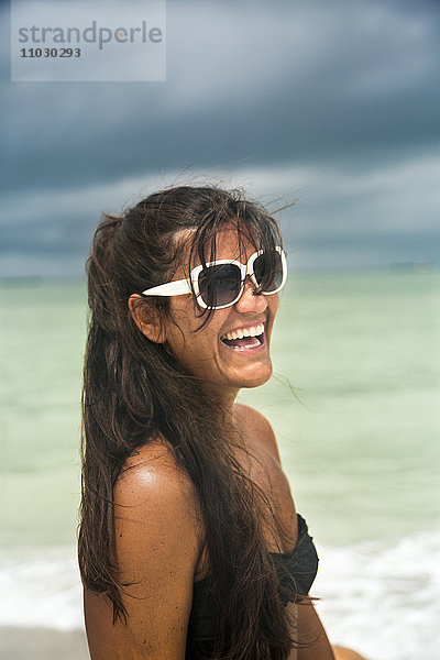 Lachende junge Frau am Strand