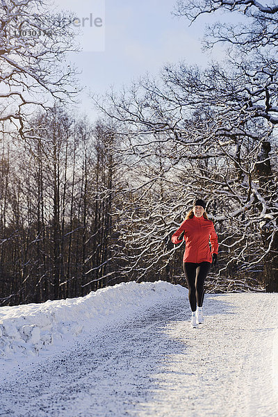 Ältere Frau beim Joggen im Winter