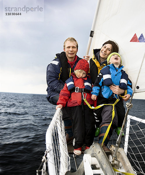 Familie im Segelboot sitzend  lächelnd