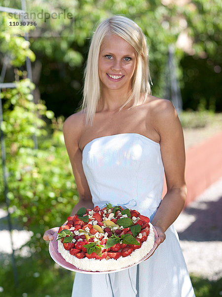 Frau hält Kuchen im Garten  Nahaufnahme
