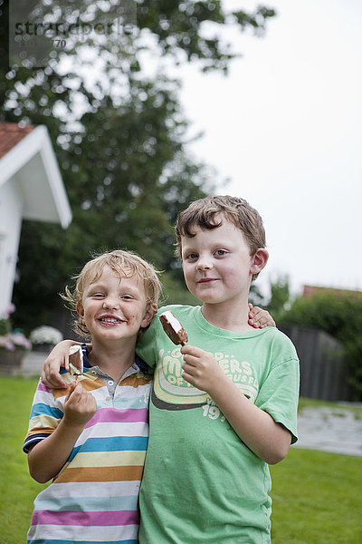 Brüder  die Eiscreme halten und in die Kamera schauen