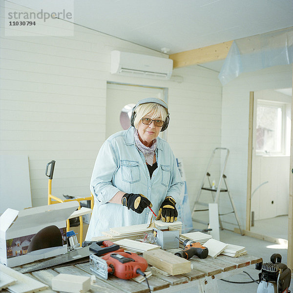 Ältere Frau bei Tischlerarbeiten