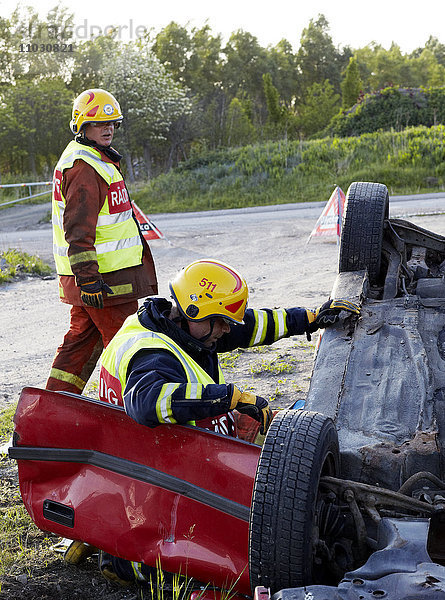 Feuerwehrleute retten Menschen aus verunglücktem Auto