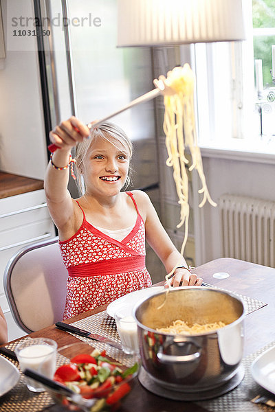Ein Mädchen serviert sich selbst Spaghetti