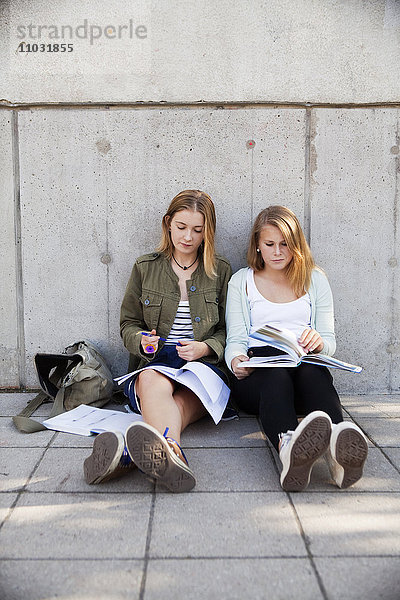 Teenager-Mädchen machen außerhalb der Schule Hausaufgaben