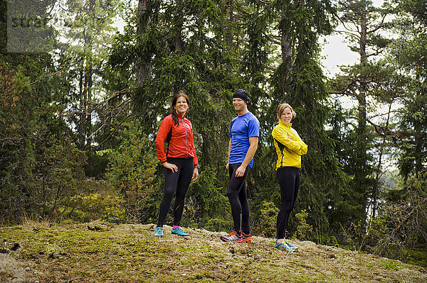 Drei Sportler stehen im Wald