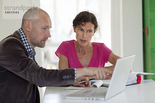 Mann und Frau arbeiten an einem Laptop