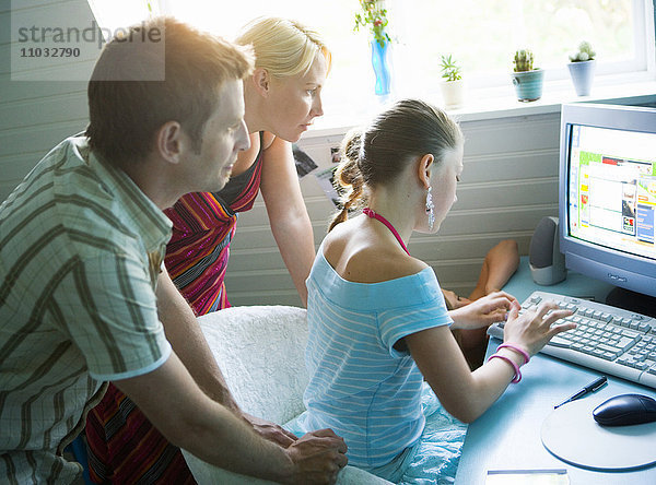 Eine Familie versammelt sich um einen Computer.