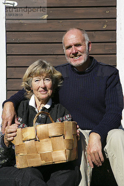 Ein älteres Ehepaar hält einen Korb.
