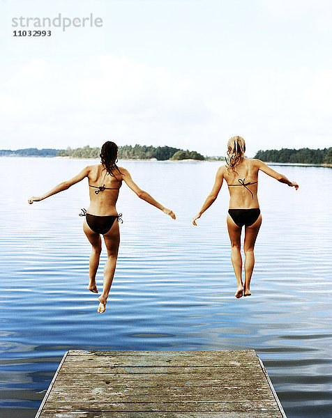 Zwei Frauen springen ins Wasser.