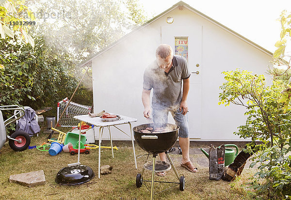 Mann beim Grillen im Garten  Schweden