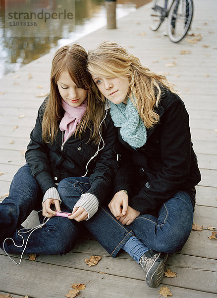 Zwei Mädchen im Teenageralter hören Musik.