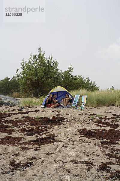 Eine Familie in einem Zelt am Strand