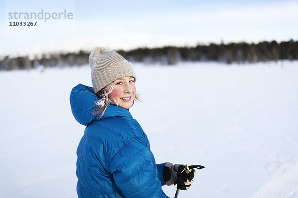 Mädchen beim Skifahren mit Strickmütze auf einem Schneefeld