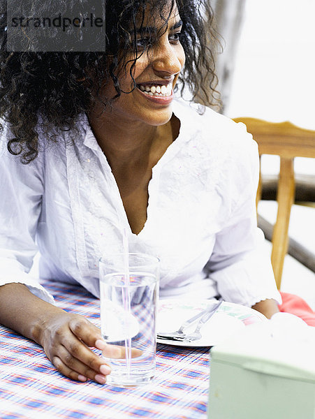 Eine lächelnde Frau in einem Restaurant im Freien.