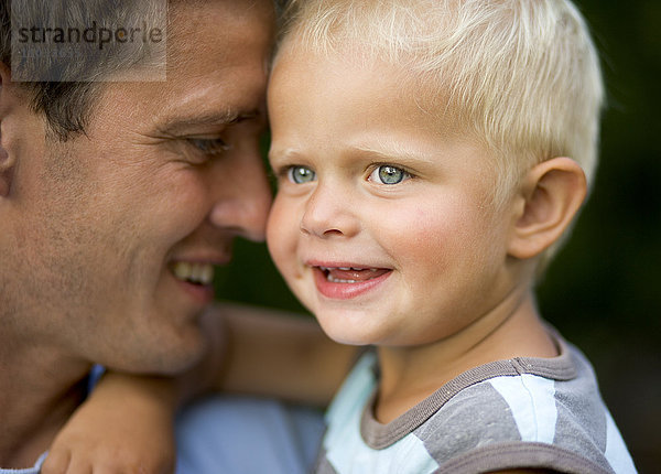 Vater und Sohn umarmen sich.