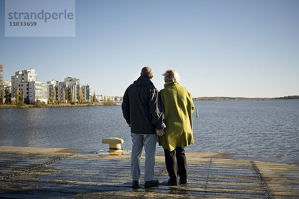 Älteres Paar schaut aufs Wasser