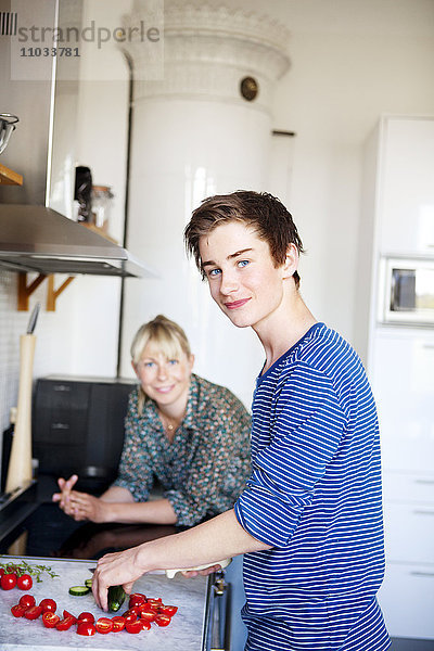 Jugendlicher mit Mutter in der Küche