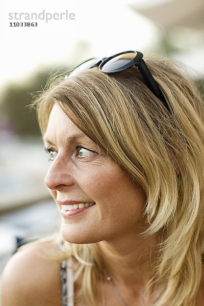 Porträt einer blonden Frau mit Sonnenbrille.