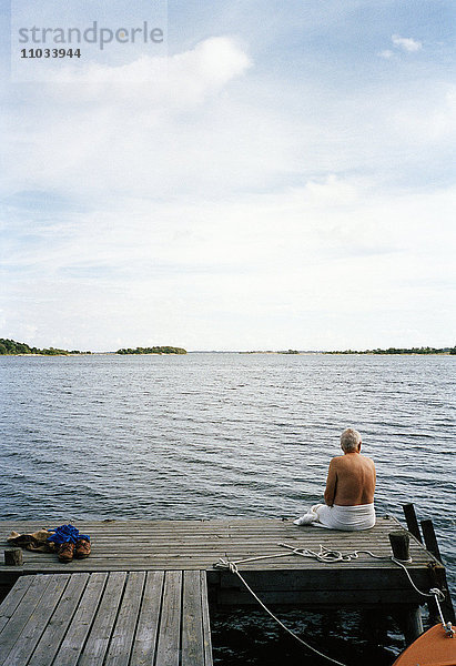 Ein Mann sitzt auf einem Pier  Stockholm archipeoago  Schweden.