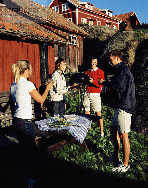 Vier Freunde beim geselligen Beisammensein  Harstena  Ostergotland  Schweden.